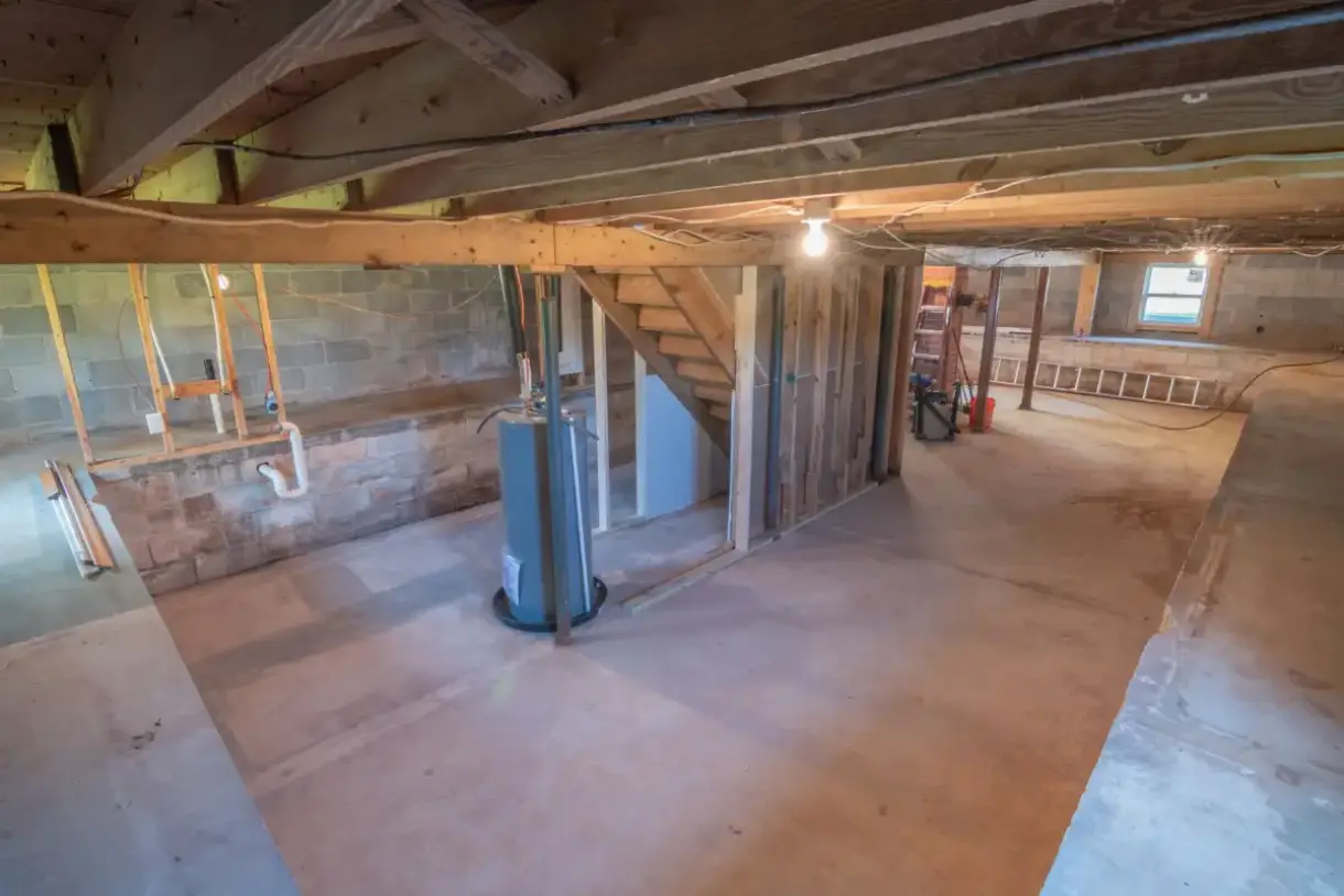 Unfinished basement with foundation walls and open joists overhead