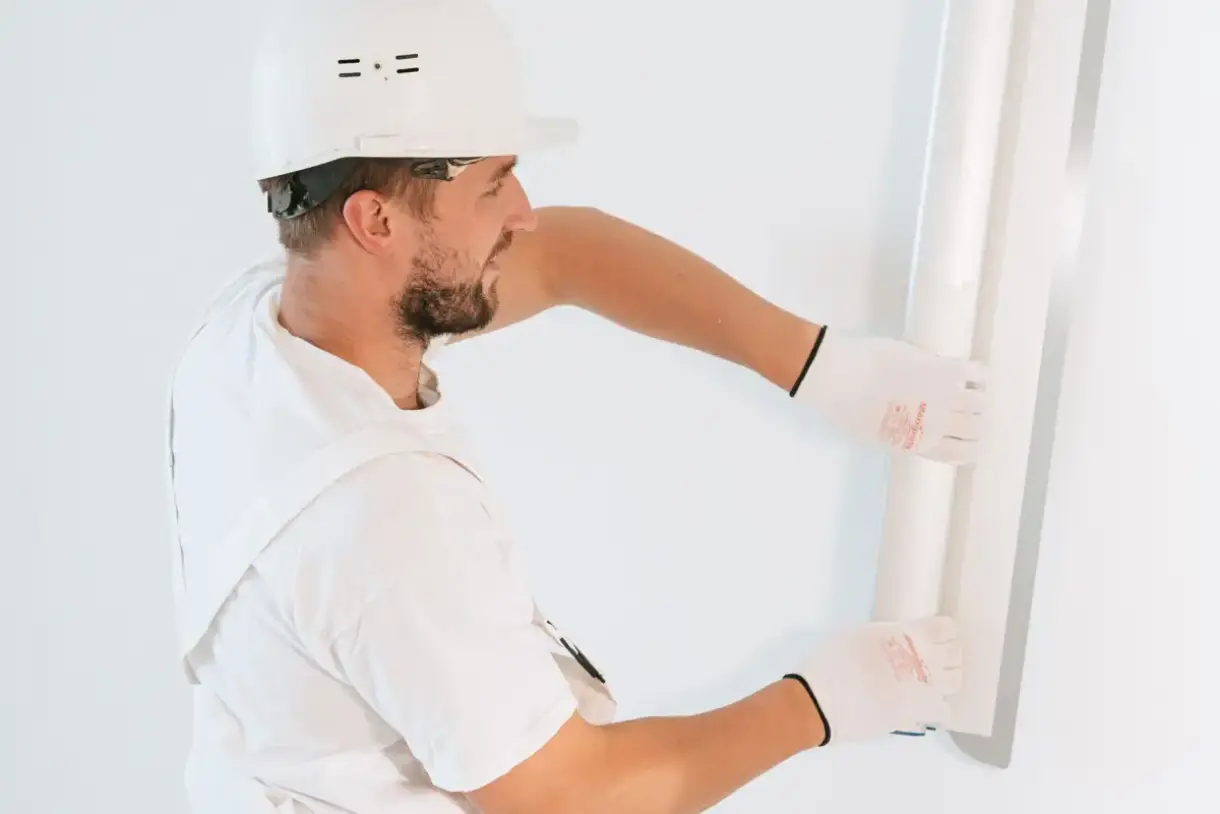 Drywall panel lifted into place against open framing during installation