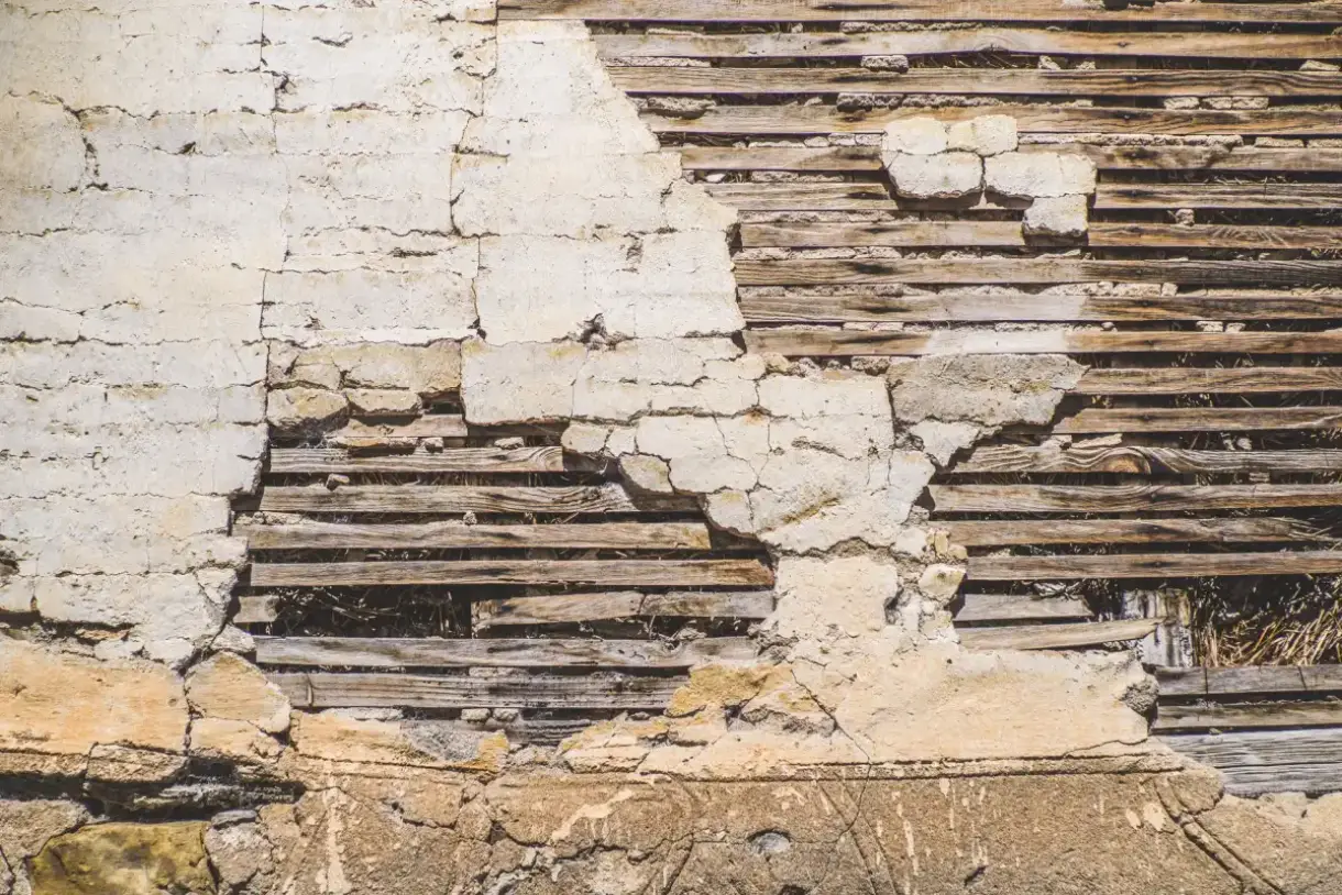 Wood lath exposed behind failed plaster on an older wall